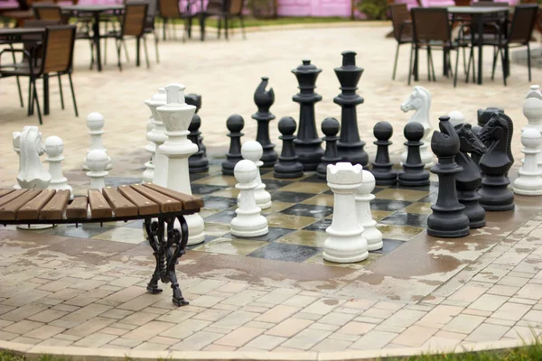 Park with chess figures autumn season. Big chessboard outdoor in tropical resort.
