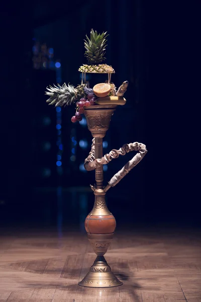 Exotic hookah. Different hookah over the bright backgrounds with smoke. Hookah with fruit flavour on wooden table in vintage style