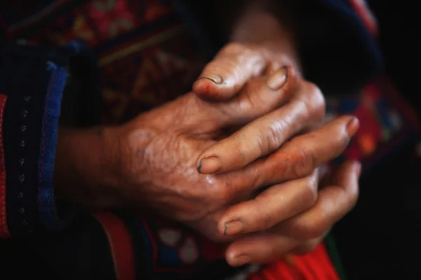 Old tribal woman with wrinkle hands clasped