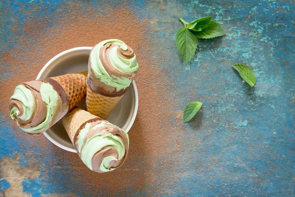 Delicious ice cream cone with mint and chocolate on a vintage wo