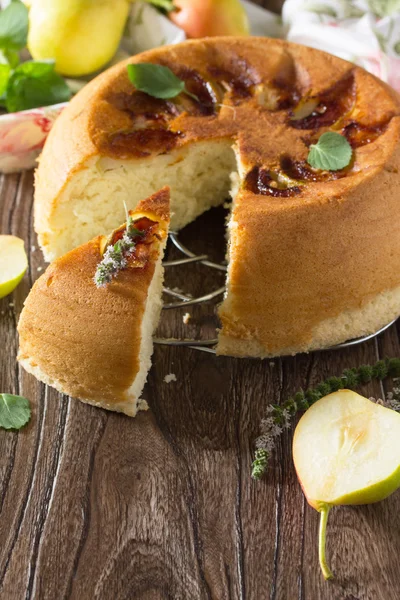 Sponge cake with caramel, cake with pears on a wooden table. Spa