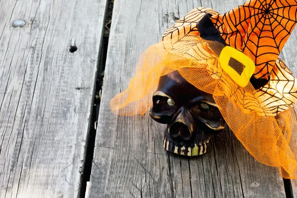 Objects decoration Halloween hat and skull on old wooden table