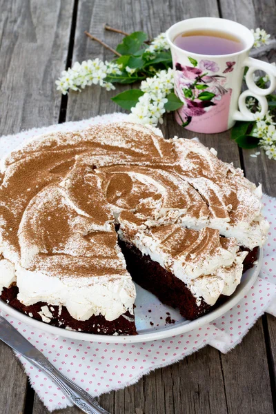 Cake chocolate-nut cake and meringue on wooden background