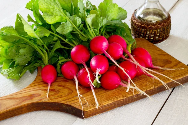 A bunch of radishes on a white wooden table