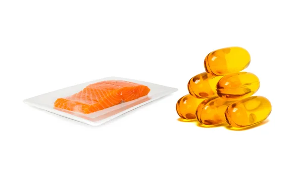 Fish oil supplement product capsules with salmon on dish isolated on white background