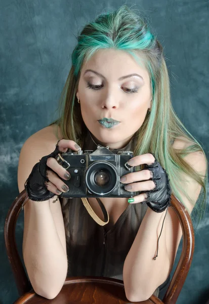 Steampunk-styled girl experiments with old fashion camera