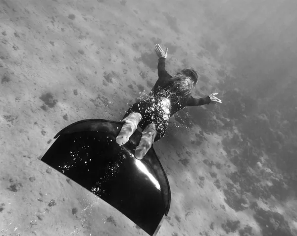 Beautiful freediver girl swims above sea bottom