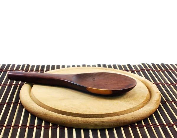 Wooden ladle on wooden cutting board and wooden mat