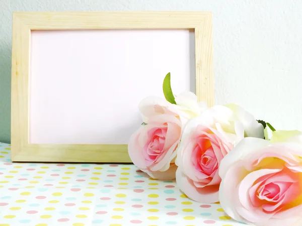 Blank photo wood frame with pink roses and gift box on sweet flower