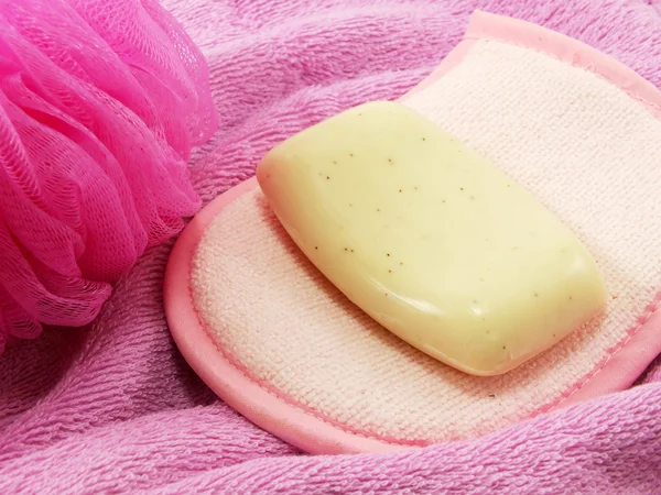 Pink towels and bath puff with white soap