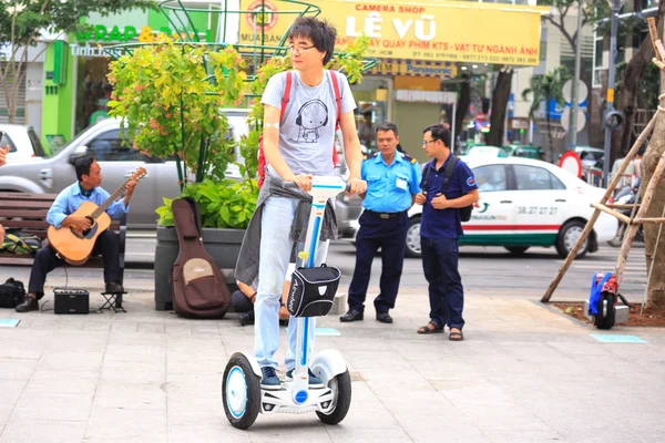 Hochiminh City, Vietnam - July 8, 2015: Man riding a Segway electric vehicle two wheels on a young tour sightseeing gyropode on Walking Street Nguyen Hue Street, HoChiMinh city center