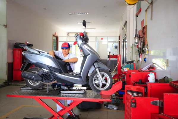 Hochiminh City, Vietnam - June 23, 2015: professional motorcycle repairman at a service center of Honda motorcycles in Ho Chi Minh City, Vietnam