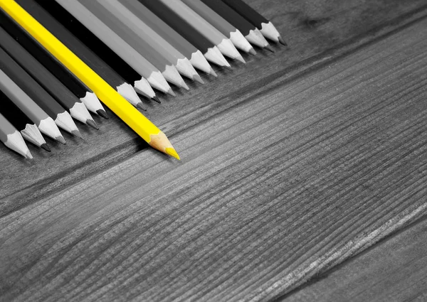 Black and white image of colored pencils with isolated yellow