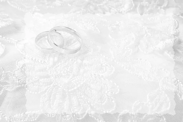 Wedding rings on wedding card, on a white wedding dress