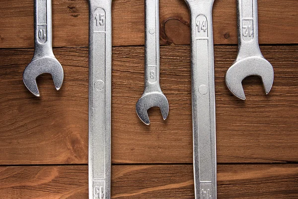 Set of wrenches. Wrenches in several different sizes on natural wooden background.