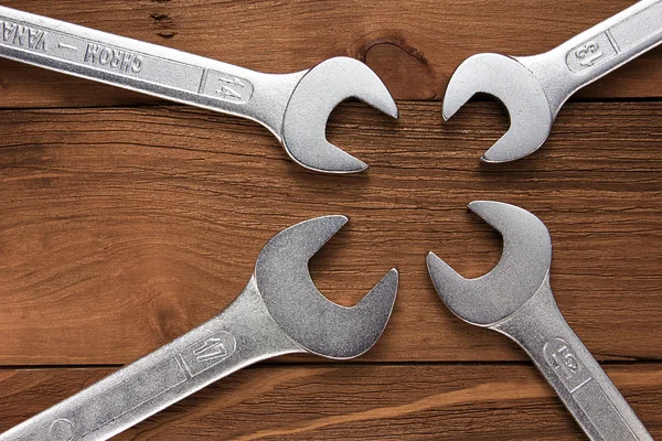 Set of wrenches. Wrenches in several different sizes on natural wooden background.
