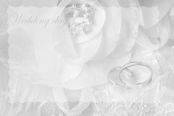 Wedding rings on wedding card, on a white wedding dress