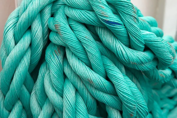 Nautical background. Old blue frayed ship rope closeup.