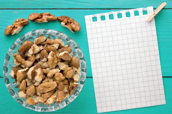 Menu background. Cook book. Recipe notebook with walnuts on turquoise wooden texture