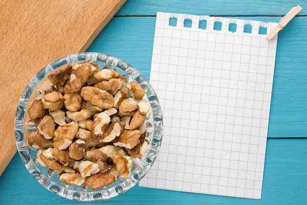 Menu background. Cook book. Recipe notebook with walnuts on turquoise wooden texture