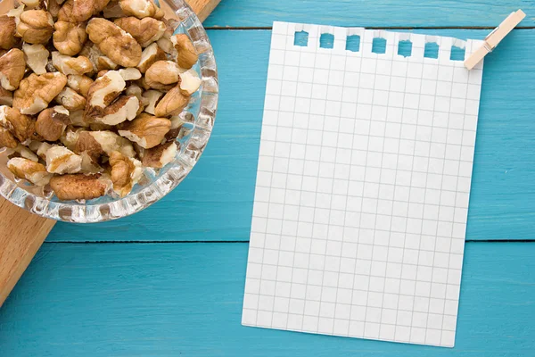 Menu background. Cook book. Recipe notebook with walnuts on turquoise wooden texture