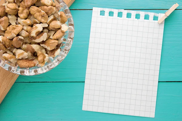 Menu background. Cook book. Recipe notebook with walnuts on turquoise wooden texture