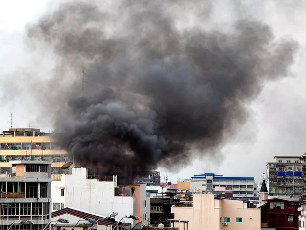 Fire burning and black smoke over the commercial building.