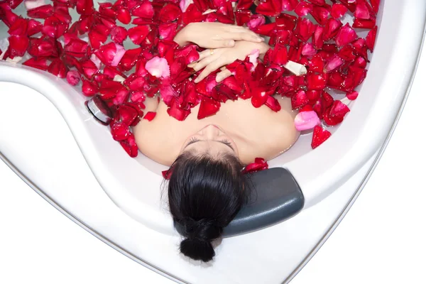 Beautiful asian woman takes a bath in jacuzzi with rose petals in thai massage spa salon., Beauty spa treatments for skin rejuvenation concept.