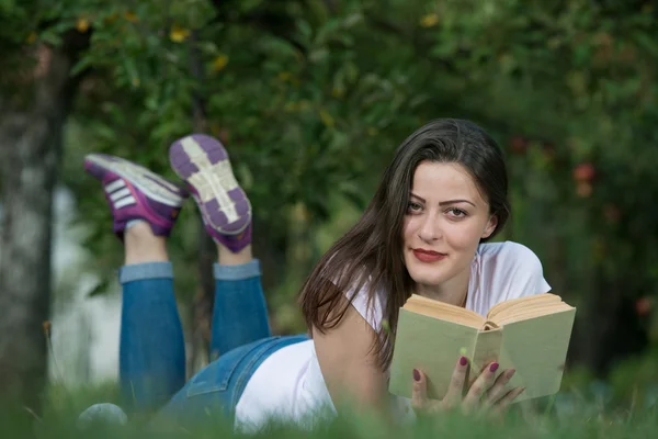 Girl lies in the nature and reading a book