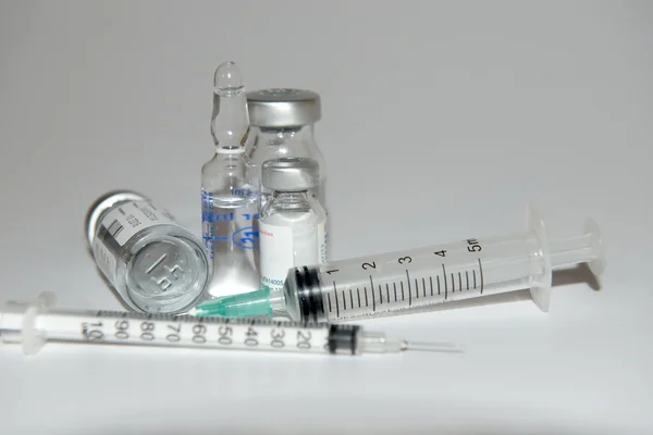 Syringe next to a drug bottle