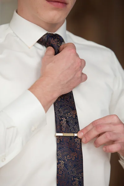 The man ties a tie