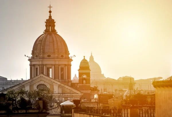 Urban landscape of Rome against the backdrop of an orange sunset.