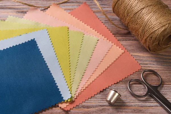 Textiles on a vintage wooden table with scissors and thimble