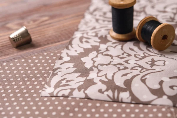 Textiles on a vintage wooden table with scissors and thimble