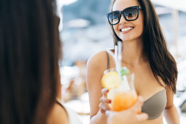 Cheerful female friends drinking cocktails