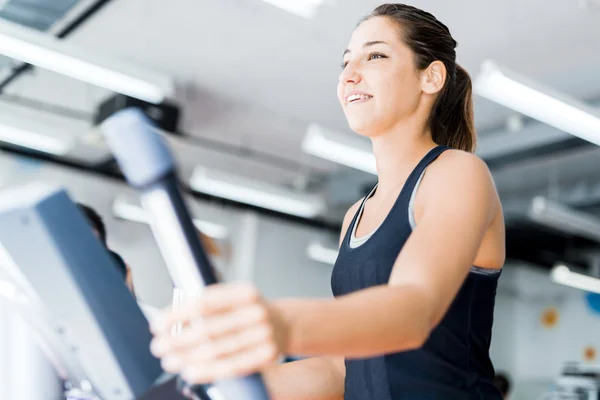 Beautiful lady using the elliptical trainer