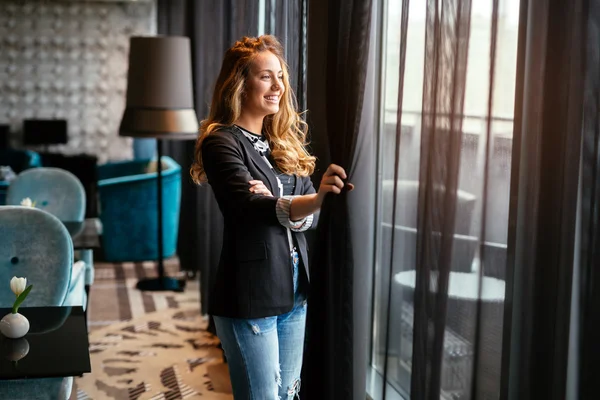 Blonde woman looking through window