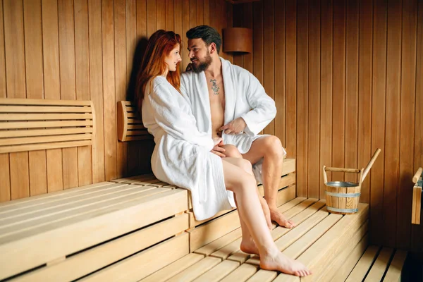 Beautiful couple relaxing in sauna