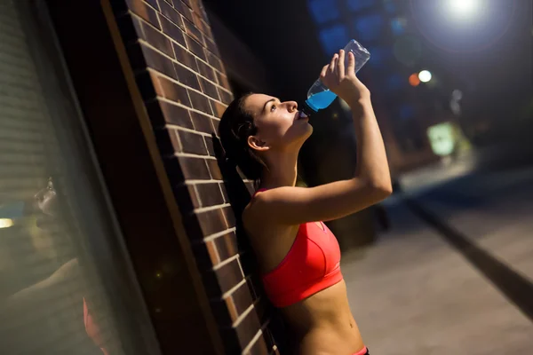 Thirsty sportswoman drinking water