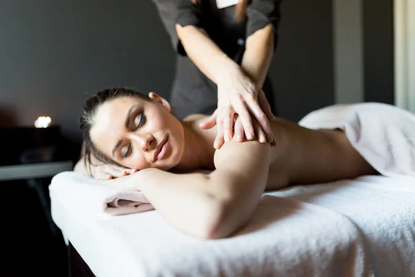 Lady having her body massaged by a masseur