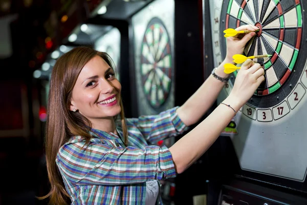 Woman playing darts in a club