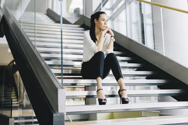 Businesswoman sitting on stairs