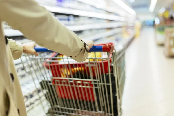 Woman pushing shopping trolley