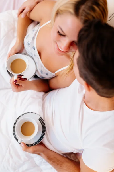Couple drinking morning coffee in bed