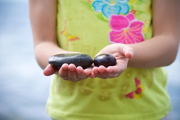 Two stones in the hands of a child