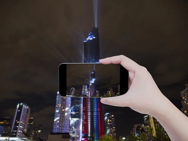 Woman hold smartphone on hand with cityscape background 1