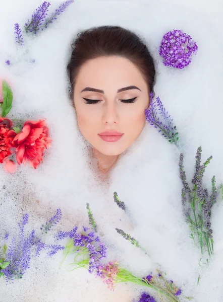 Woman with flowers in the foam bath