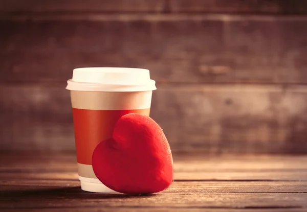 Cup of coffee and red heart shaped toy
