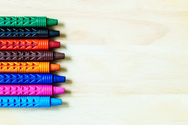 Wax crayons on a wooden background with copy space