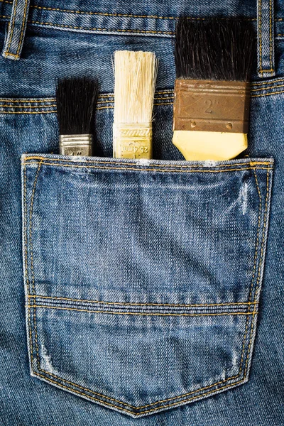 Paint brushes in jeans pocket